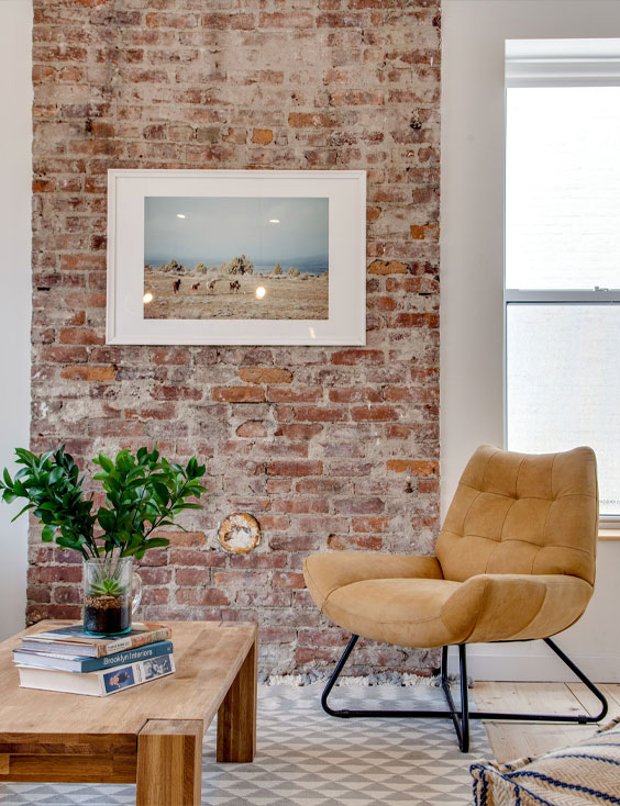 Exposed brick wall with white frame and leather chair
